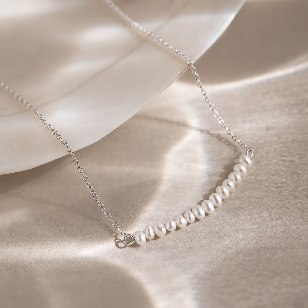 Pearl necklace on a soft beige fabric background